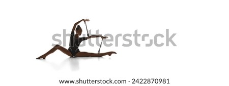 Artistic, beautiful teen girl, rhythmic gymnast in black costume, performing with clubs against white studio background. Concept of sport, competition, art. Banner. Empty space for text, ad. Event