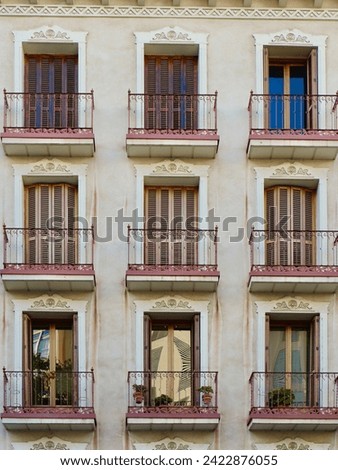 Elegant windows on vintage authentic building of beige colours. Old-fashioned historical buildings in Zaragoza, Aragon, Spain. Vertical photo.