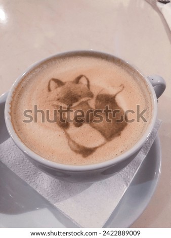 A cup of coffee with a picture of a raccoon on milk foam