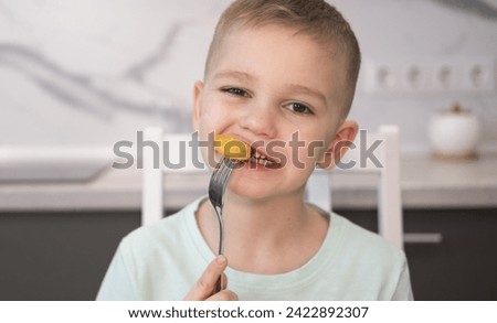 Close up of happy child eating fast food at home chicken nuggets. Boy eats junk food at home.