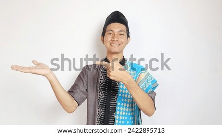 Asian Muslim man with a gesture pointing to the side on a white background