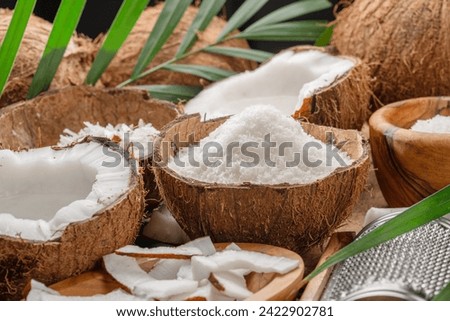 Fresh opened coconuts along with coconut slices, flakes and coconut leaves on a wooden table. Nice fruit background for your projects. 