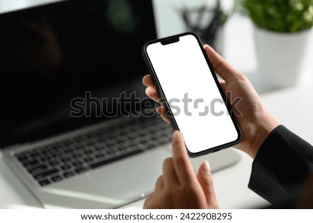 Unrecognizable businesswoman using smartphone at office desk0 Empty screen for your text message