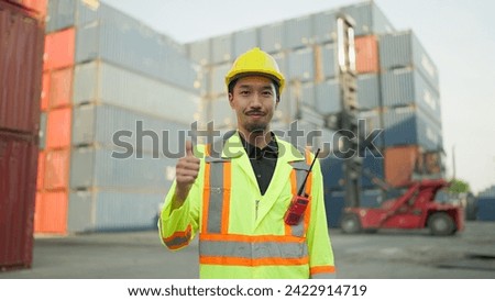 Portrait young asian japanese foreman in hardhat and safety uniform standing giving thumbs up while smiling at the camera. Engineer giving thumbs up while looking at camera. Logistic concept