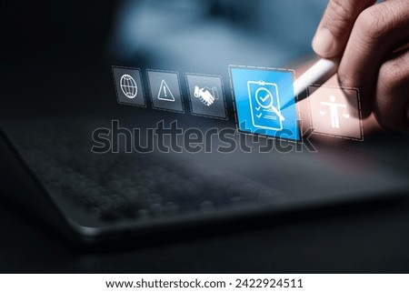 Compliance in business concept. Person use laptop with compliance icon on virtual screen, ensuring the enforcement of laws, regulations, and standards. Stay in line with business policies. Royalty-Free Stock Photo #2422924511