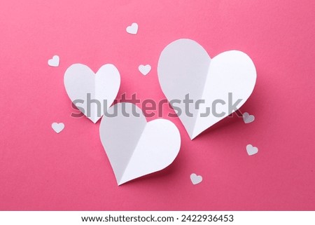 White paper hearts on pink background, flat lay