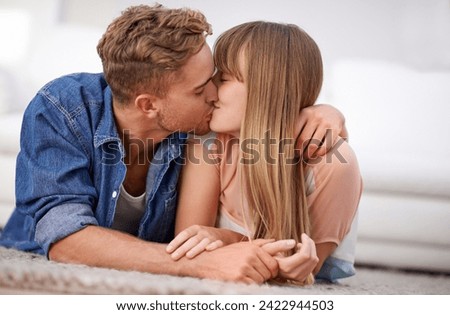 Couple, kiss and relax on floor, living room and happy with love, joy and together in relationship. Lovers, romantic and date with partner, content and touch with hands, devotion and lying on mat Royalty-Free Stock Photo #2422944503