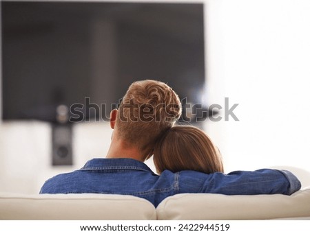 Couple, together and hug watching TV, home and relaxing for break, couch or sofa while bonding. Partners, streaming and enjoyment of subscription, relax and embrace in lounge for romance and love Royalty-Free Stock Photo #2422944519