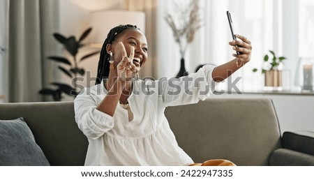 Smile, selfie and black woman with peace sign, funny face and relax on sofa in living room. V hand, picture and happy African person or influencer at home on couch on social media with tongue out