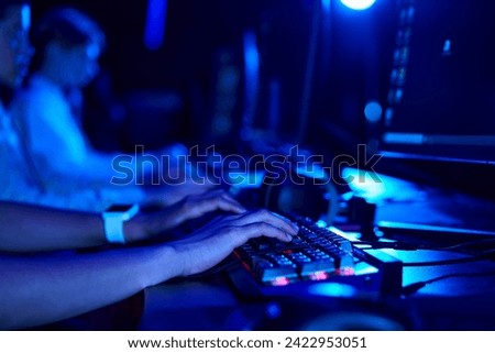 cropped photo of female hands, young gamer using computer keyboard while playing game, cybersport