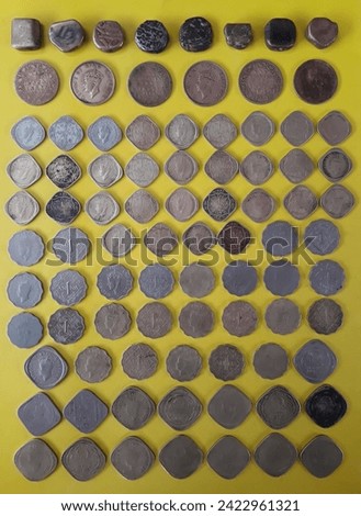 old Indian coin with yellow background,old Indian currency image,old coin anna,dhela,damrhi,one anna,half anna,two anna,Naya paisa,one paisa,kaudi,old rupees,British coins, Royalty-Free Stock Photo #2422961321