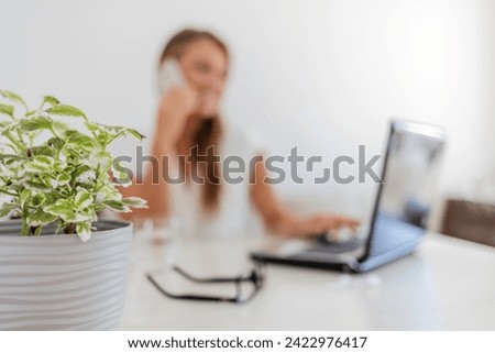 Cropped shot of an attractive young woman businesswoman making a phonecall while working on her laptop at home.