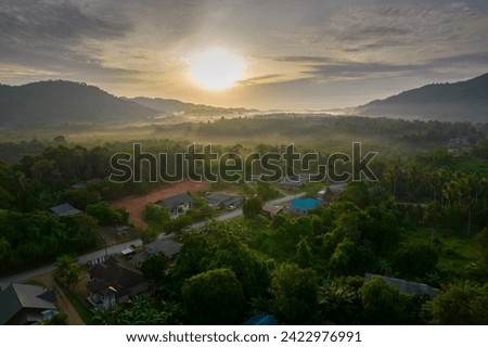 A landscape drone shot of a rural village at sunrise