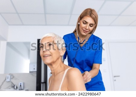 Young female doctor listen to senior patient heart chest with stethoscope at clinic meeting. Woman GP checkup examine woman client with phonendoscope. healthcare concept.