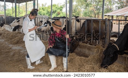 A husband and wife are checking the health of cows on their farm and recording the information on paper.