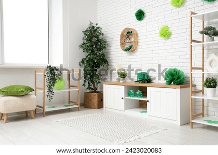 Interior of light living room with white furniture and decorations for St. Patrick's Day celebration Royalty-Free Stock Photo #2423020083