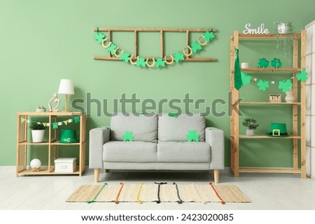 Interior of festive living room with grey sofa and decorations for St. Patrick's Day celebration Royalty-Free Stock Photo #2423020085