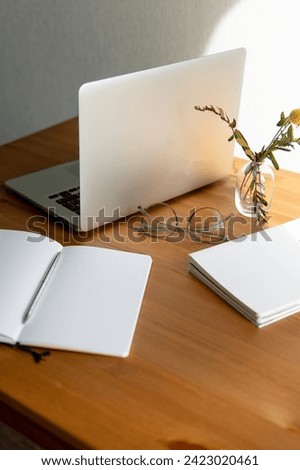 business background. glasses and notebooks are white and grey. notebook in a cage on a beautiful wooden table. Close-up with a blurred background.