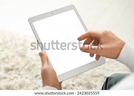Young man using tablet computer on online date at home, closeup