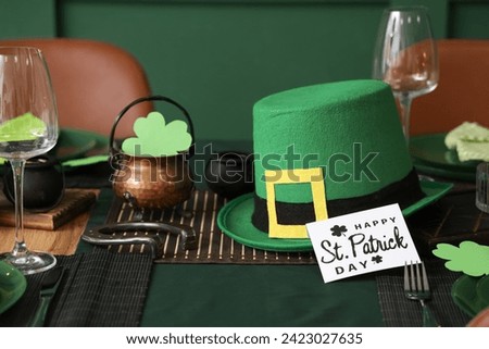 Festive table serving with leprechaun's hat and greeting card for St. Patrick's Day celebration, closeup