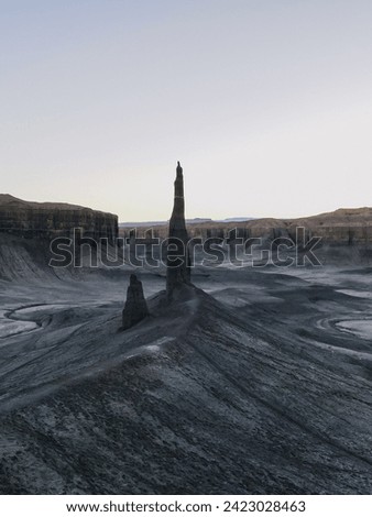 Long Dong Silver Spire in Utah Badlands, a towering geological formation sculpted by erosion. Its unique silhouette against the desert horizon exemplifies the raw beauty of nature's artistic forces. Royalty-Free Stock Photo #2423028463