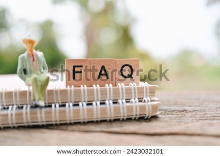close up FAQ wooden text block and notebook on wood table, Frequently Asked Questions