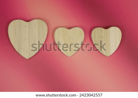 Wood heart shape on pink red background 