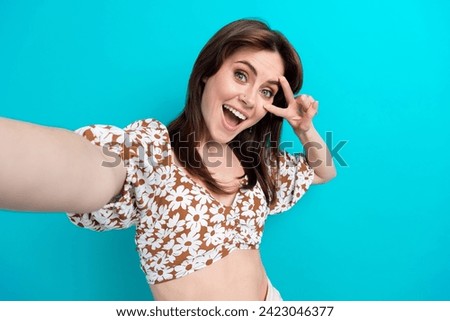 Selfie photo of beautiful young woman model cover face make v sign laughing in positive mood isolated on aquamarine color background