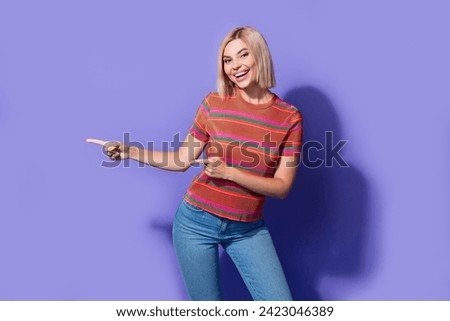 Portrait of smiling young model woman blonde bob hair pointing fingers stock photo advertisement isolated on violet color background