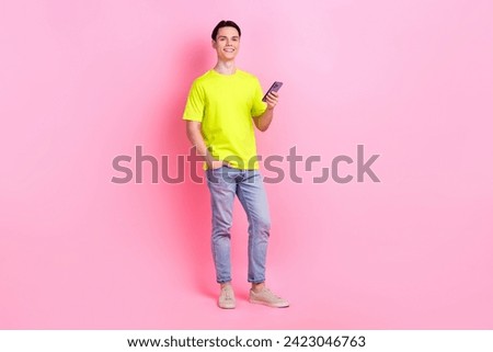 Full length photo of positive funky man dressed yellow t-shirt chatting instagram twitter telegram facebook isolated pink color background