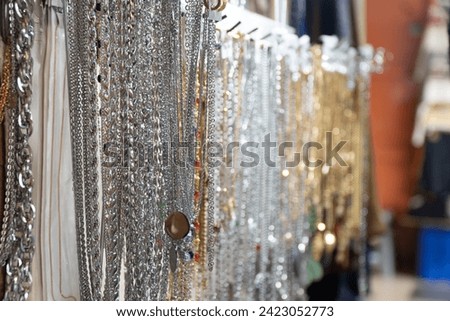 Steel necklace sold by street merchants on a busy sidewalk at Petak 6 street market Royalty-Free Stock Photo #2423052773
