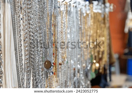 Steel necklace sold by street merchants on a busy sidewalk at Petak 6 street market Royalty-Free Stock Photo #2423052775