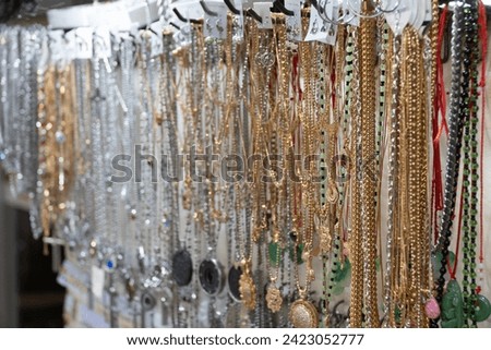 Steel necklace sold by street merchants on a busy sidewalk at Petak 6 street market Royalty-Free Stock Photo #2423052777