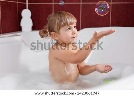 Little girl having fun in bathtub at home