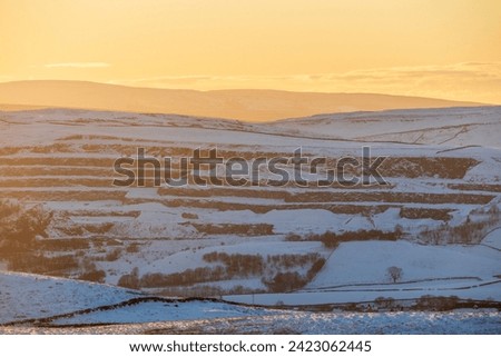Sunset in the Yorkshire Dales National Park in England during winter, with a view across to the quarry above Horton in Ribblesdale.

Lots of snow on the ground and golden sunshine. Royalty-Free Stock Photo #2423062445