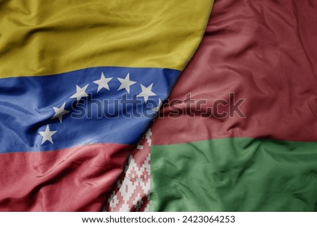 big waving national colorful flag of belarus and national flag of venezuela . macro