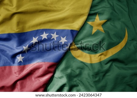 big waving national colorful flag of mauritania and national flag of venezuela . macro