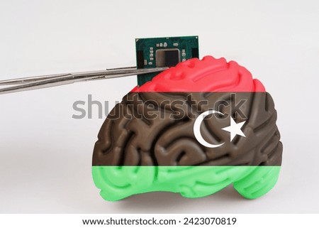 On a white background, a model of the brain with a picture of a flag - Libya, a microcircuit, a processor, is implanted into it. Close-up