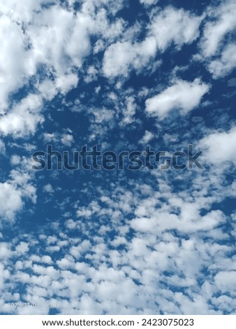 Un cielo azul abrigado con nubes  Royalty-Free Stock Photo #2423075023