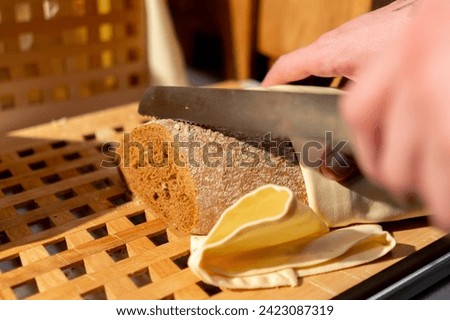 a buffet line in a hotel restaurant a guest cuts bread with knife during continental breakfast