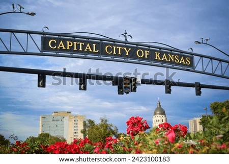 Capital City of Kansas Arch Signage Over Capitol Dome and Flowers
