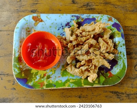 Fried crispy mushrooms and spicy sauce - vegetarian style food served on a picture serving plate.