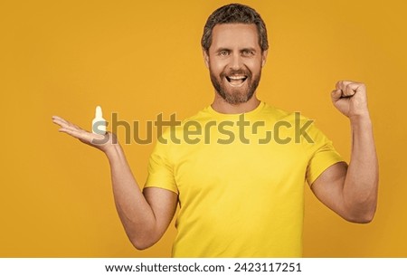 happy man with nasal medicine in studio. photo of man with nasal medicine drops Royalty-Free Stock Photo #2423117251