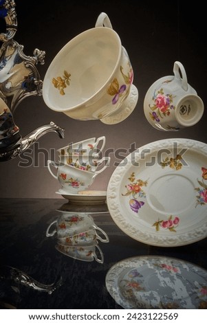 Silver coffeepot and floating coffee cups, Mad Hatter Royalty-Free Stock Photo #2423122569