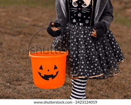 Halloween trick and treating with a orange pumpkin candy bucket