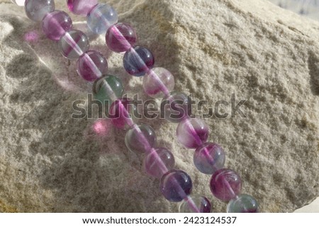 Round smooth beads made of natural multicolored fluorite. Royalty-Free Stock Photo #2423124537