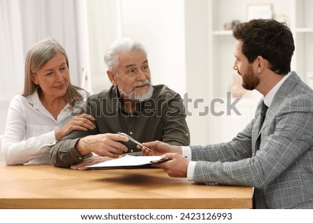 Notary consulting senior couple about Last Will and Testament in office Royalty-Free Stock Photo #2423126993