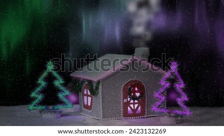 Winter picture.  The house is decorated with a Christmas wreath and bright Christmas trees against the background of the Northern Lights.