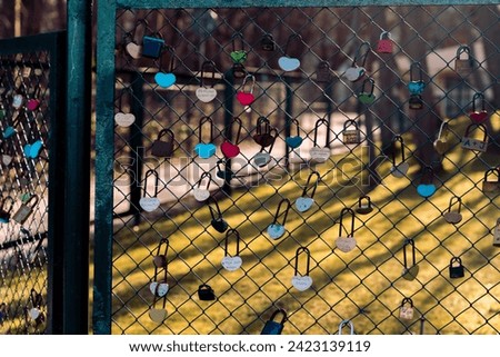 many colorful padlocks hanging on the fence.