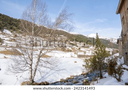 The Incles Valley is one of the many superb natural sites Andorra has to offer visitors.   Landscape of the wooden chalets by the river. Pyrenees mountains in winter time.